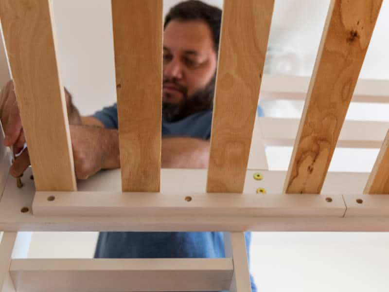 Man assembling wooden bed slats